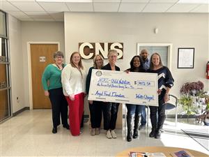 child nutrition staff holding a check