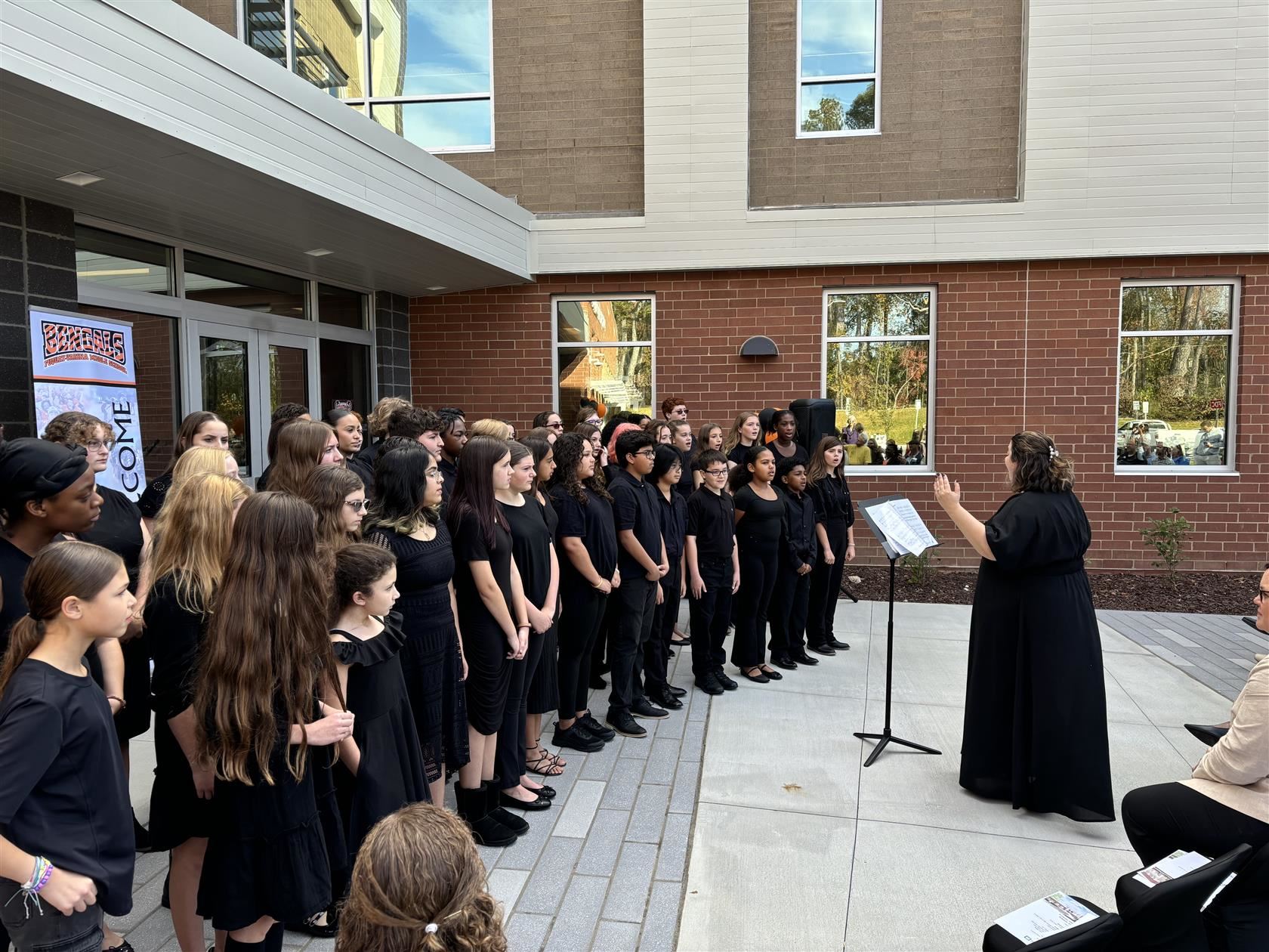 Choir students perform outside the school