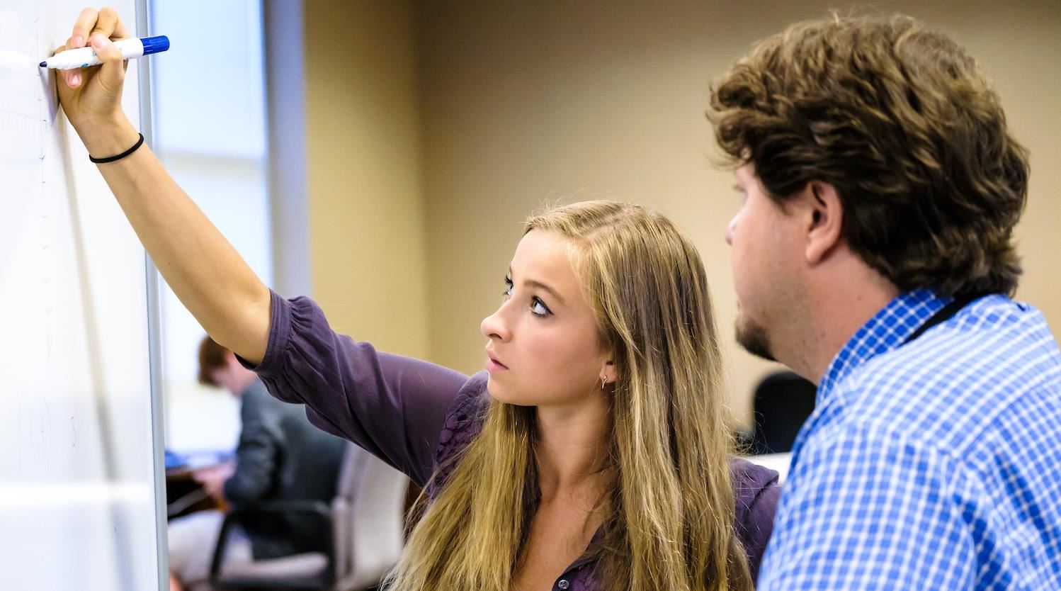 Student at an Early College High School at whiteboard with teacher 