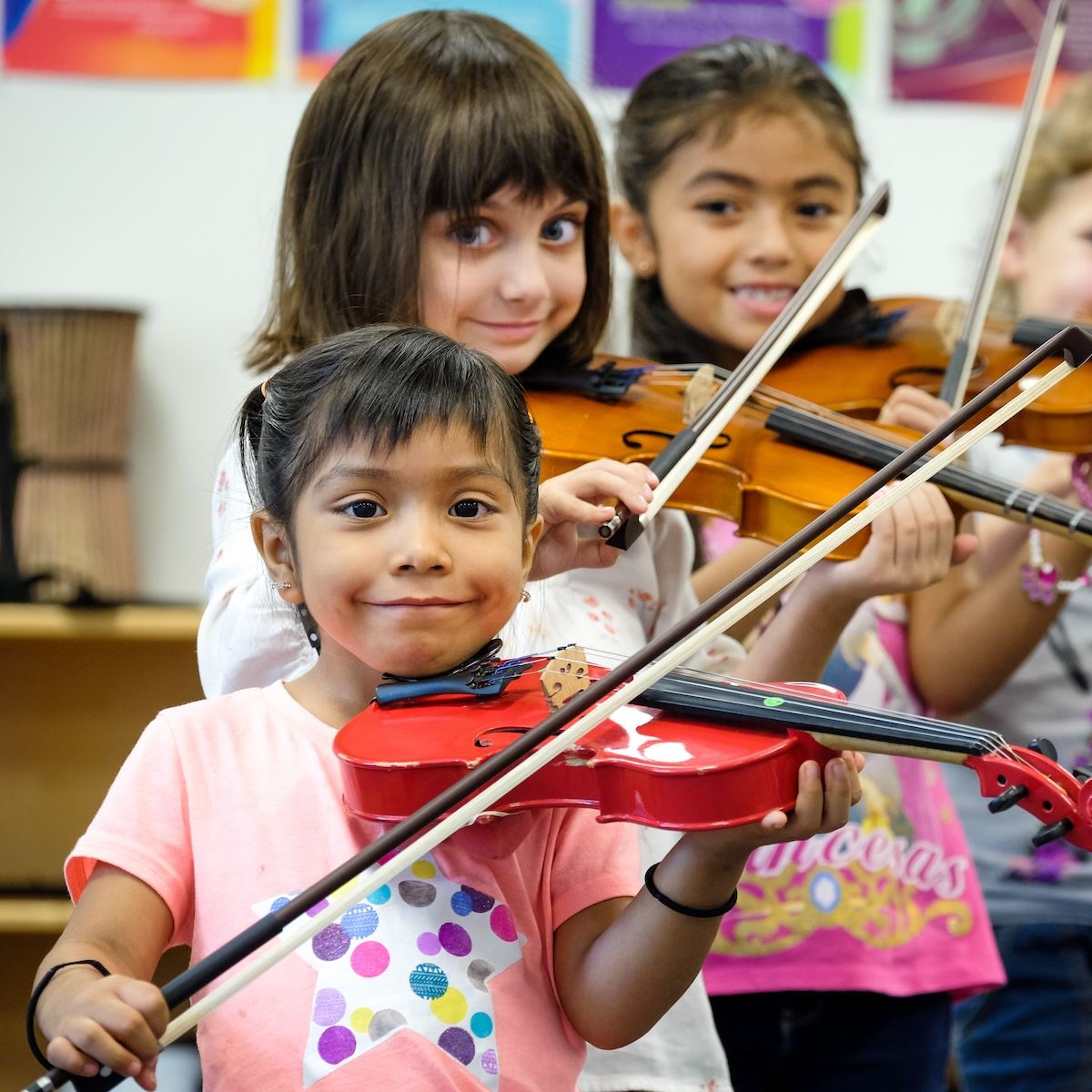  A group of young elementary students practice playing violin together