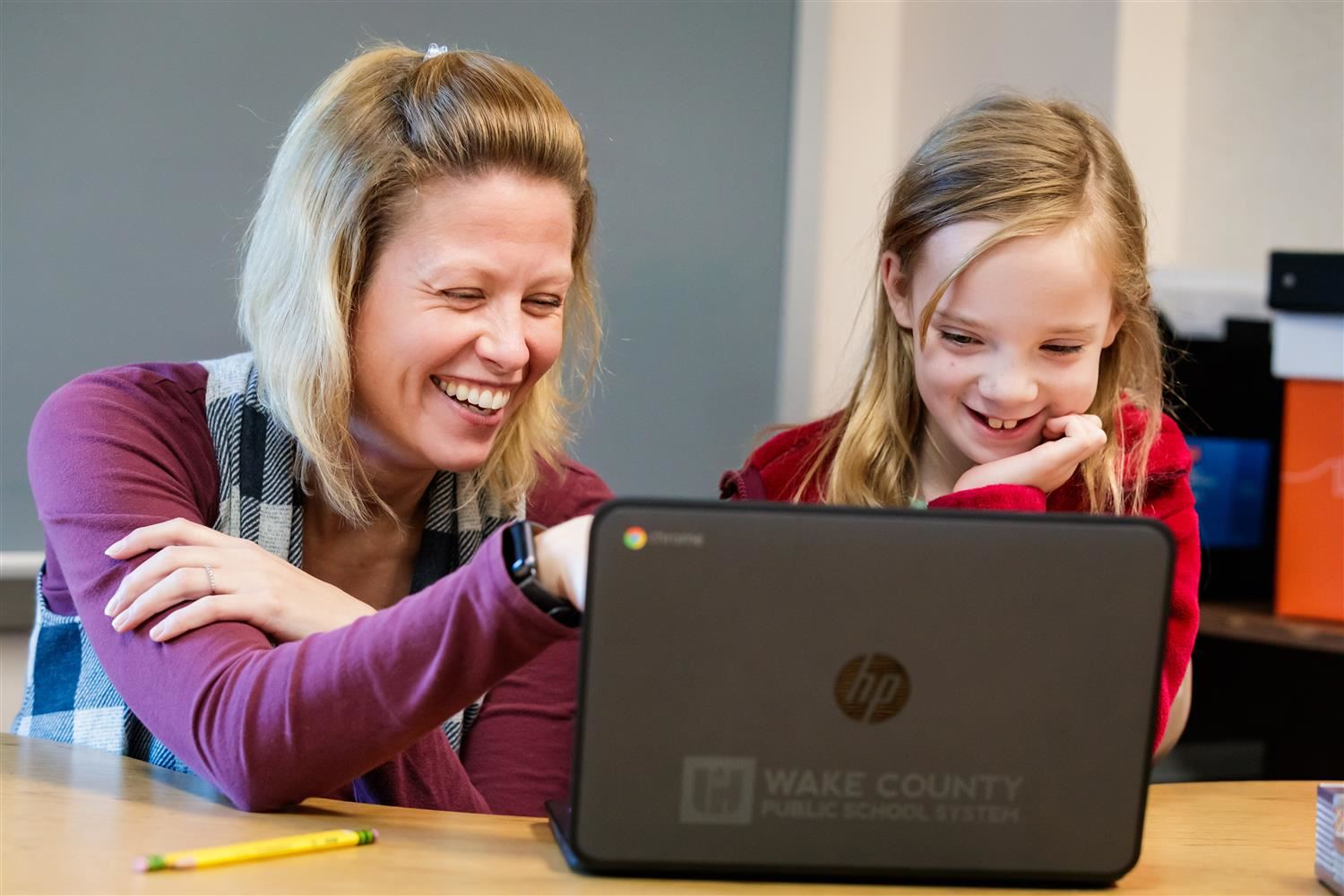 adult and child looking at computer 