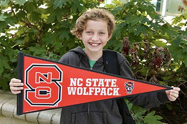 photo of student holding up a north carolina state university flag 