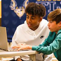  Photo of students with a laptop.