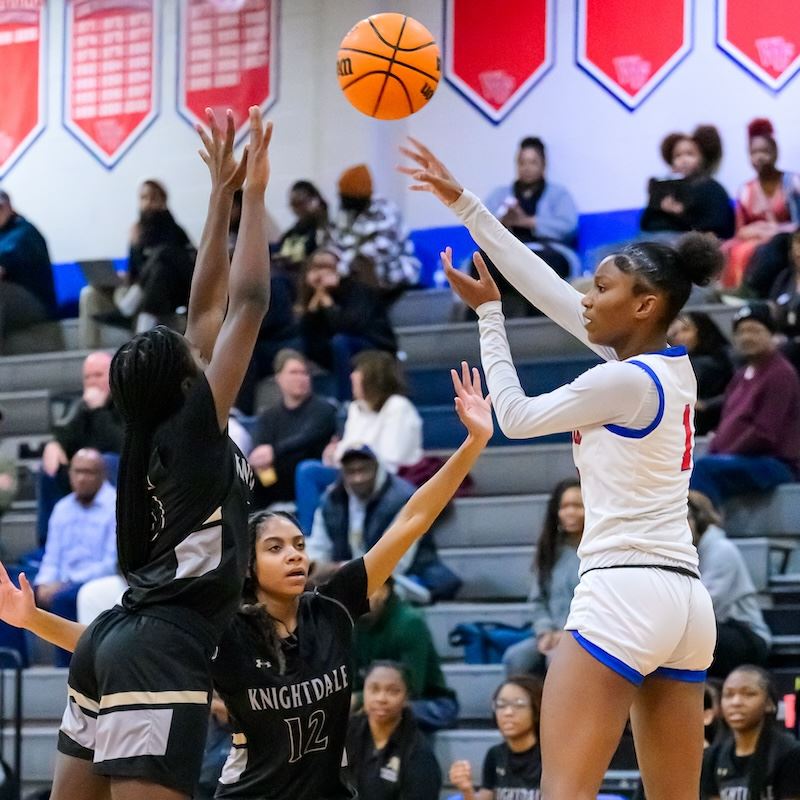  An action shot from a basketball game with a crowd in the background.