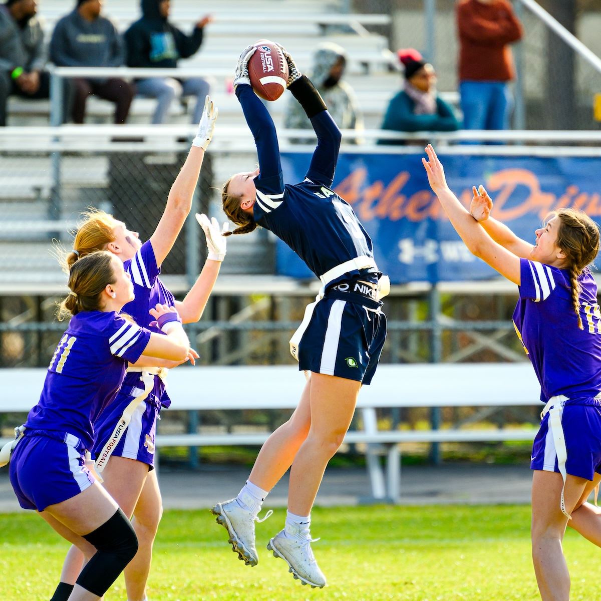  A girl leaps into the air to catch a football