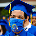  photo of a graduate wearing a cap and gown and a mask