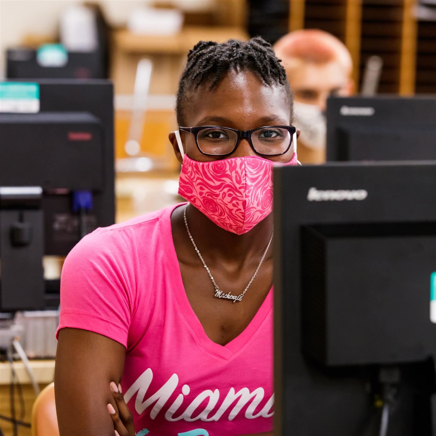  photo of student with mask on in a computer lab