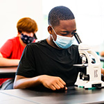  student looking into microscope