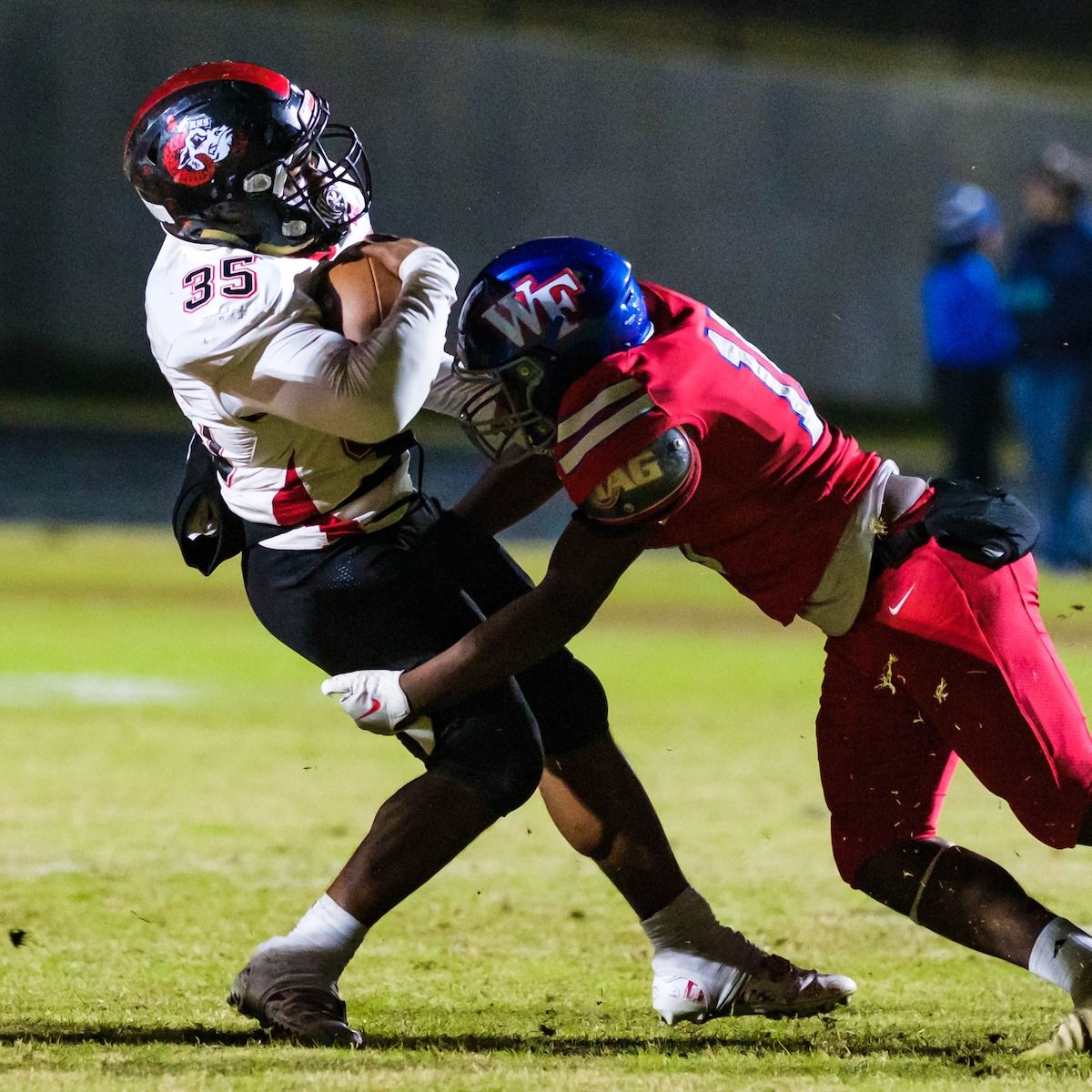  A running back is tackled by another football player