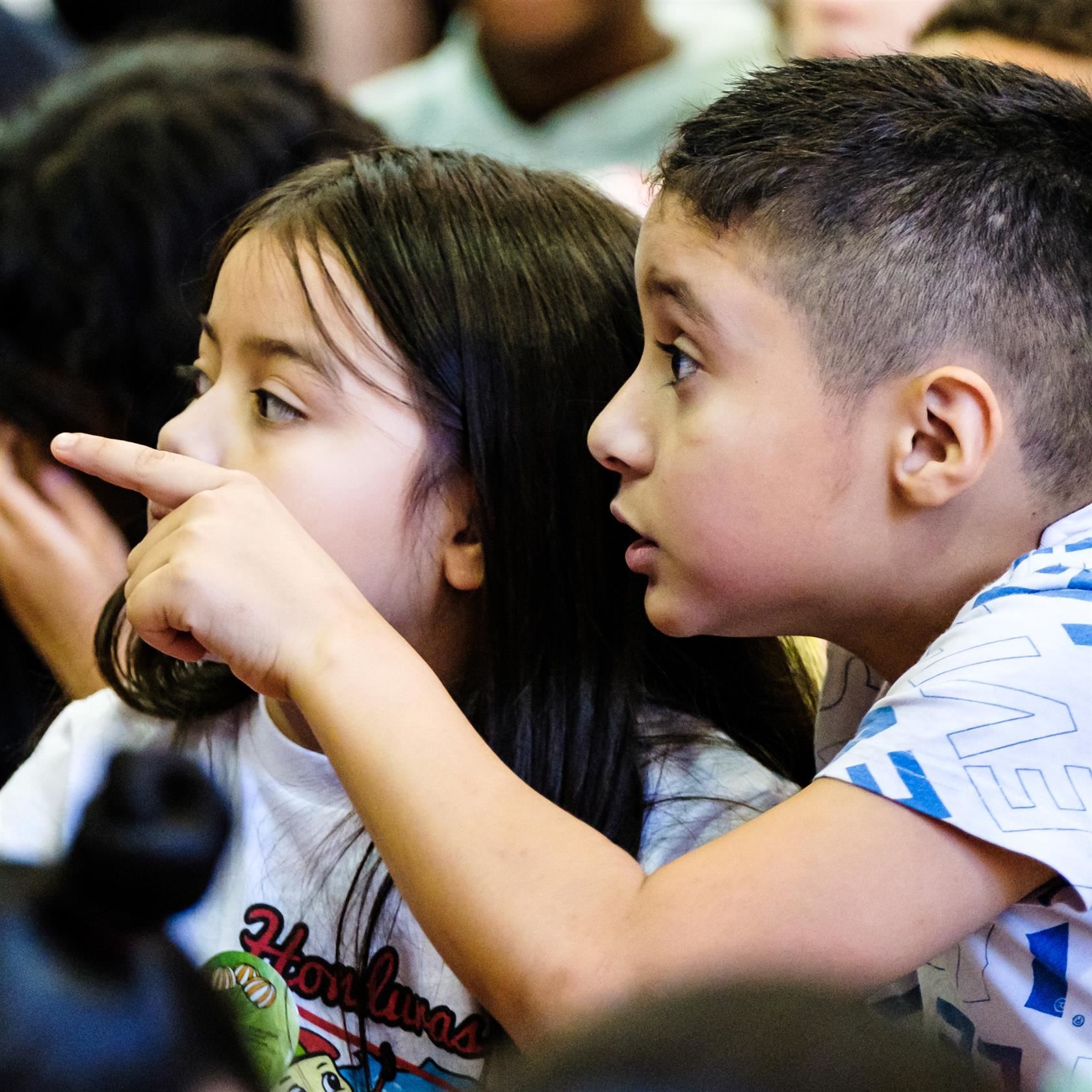 Magnet students watch a school assembly with joy