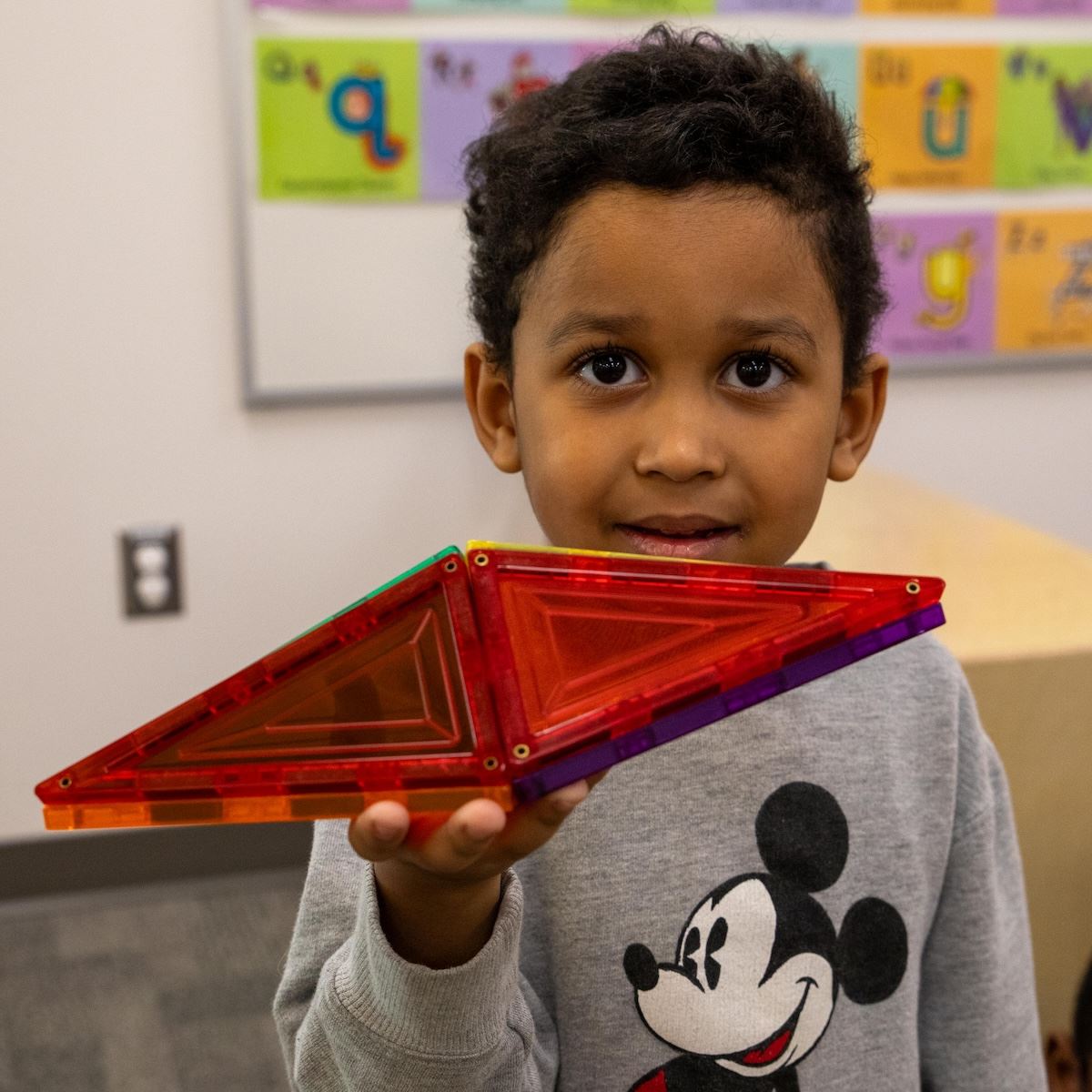  A Pre-K student holds up his building block creation