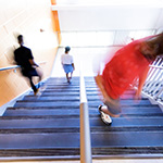  blurry image of students walking up a staircase