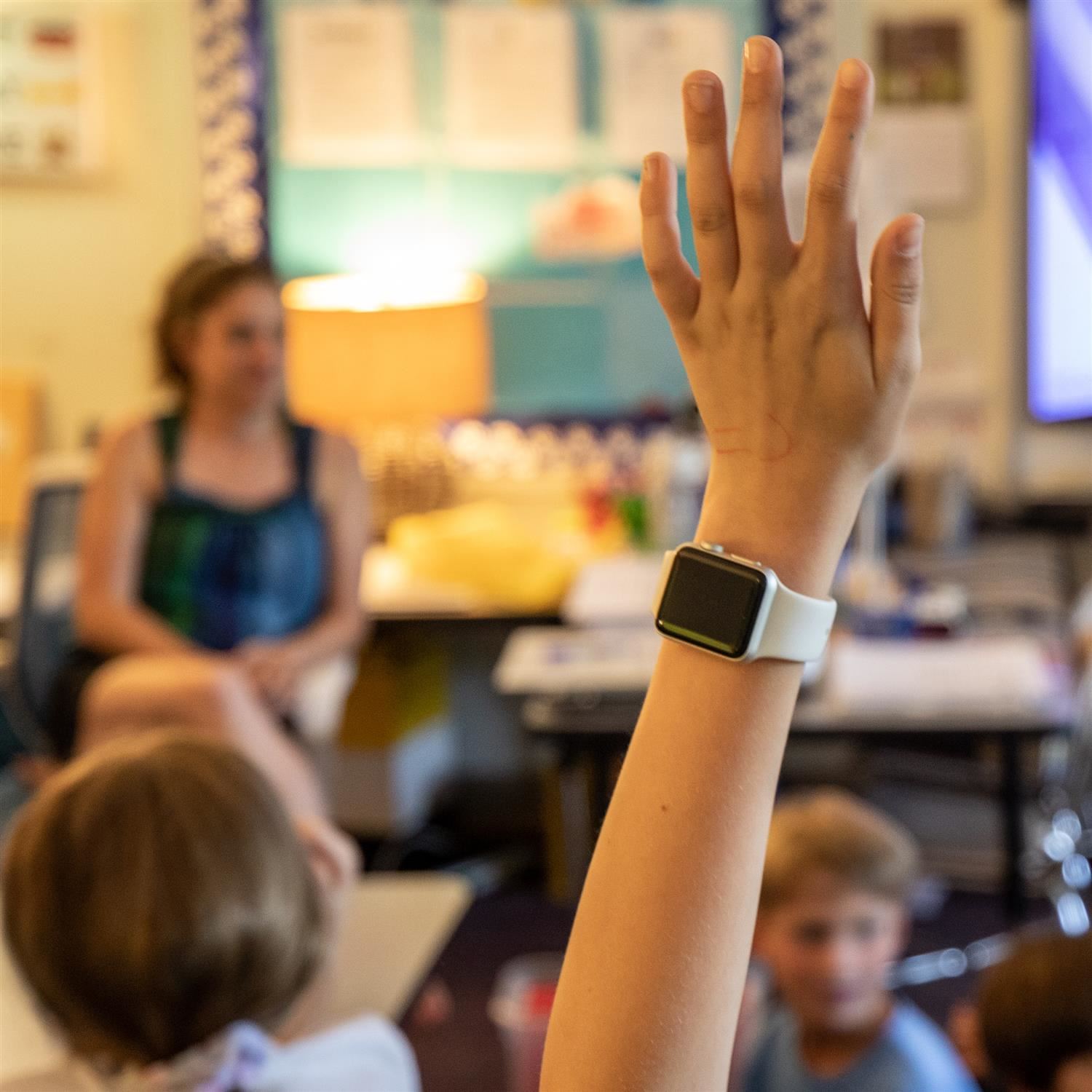 student with their hand raised