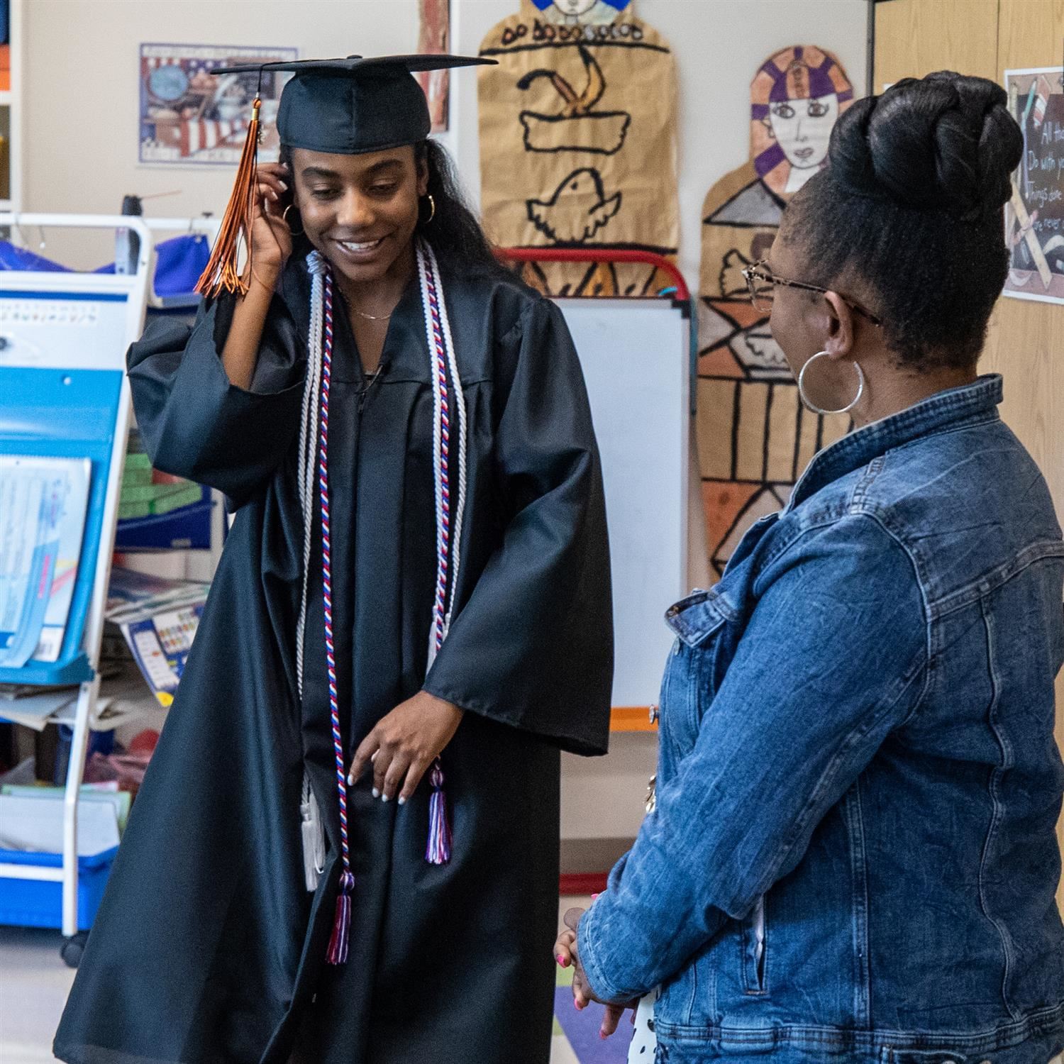 Highschool graduate smiling with teacher