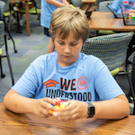  Magnet student solving Rubiks Cube puzzle