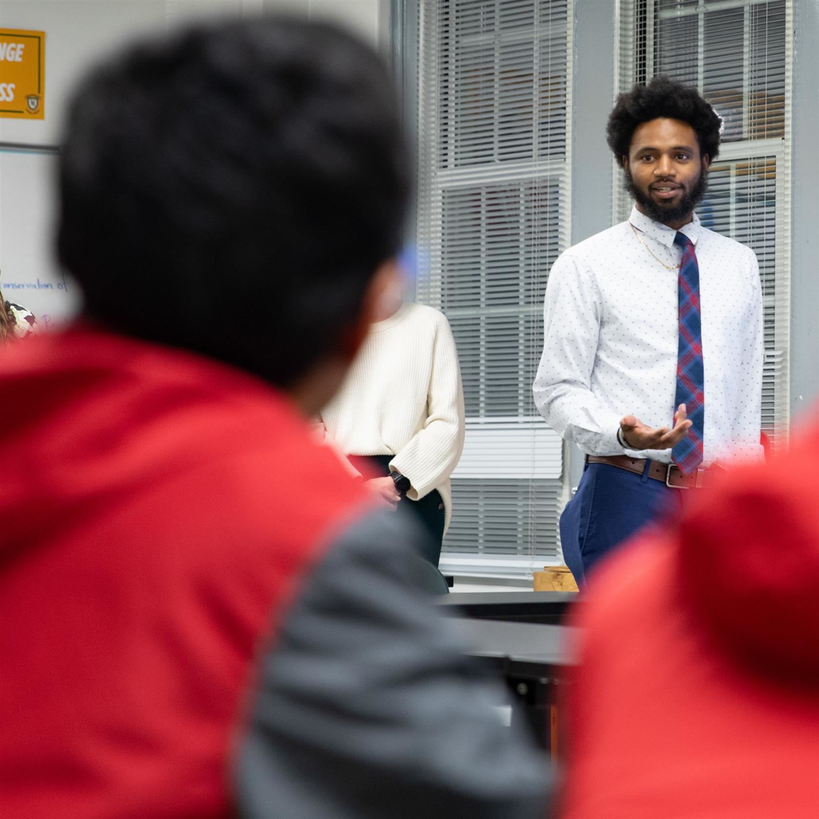  A teacher gives instruction to students in a classroom