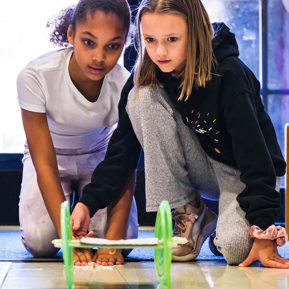  Two students watch their engineering experiment