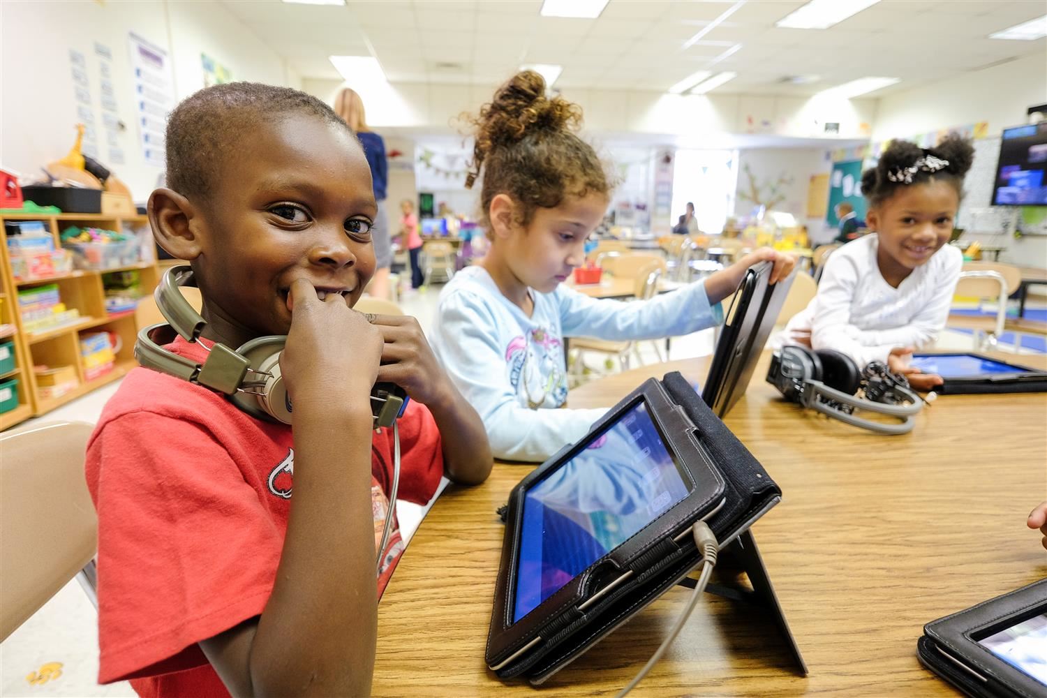 Kindergarten students working on tablets 