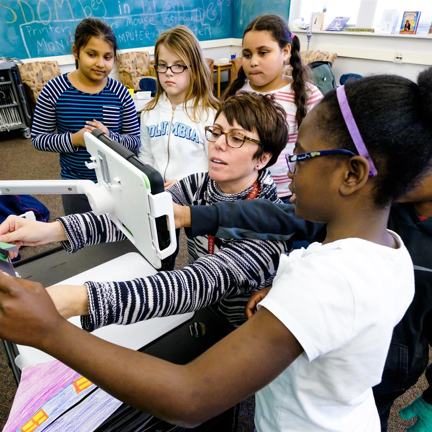  Teacher looking at data pad with students
