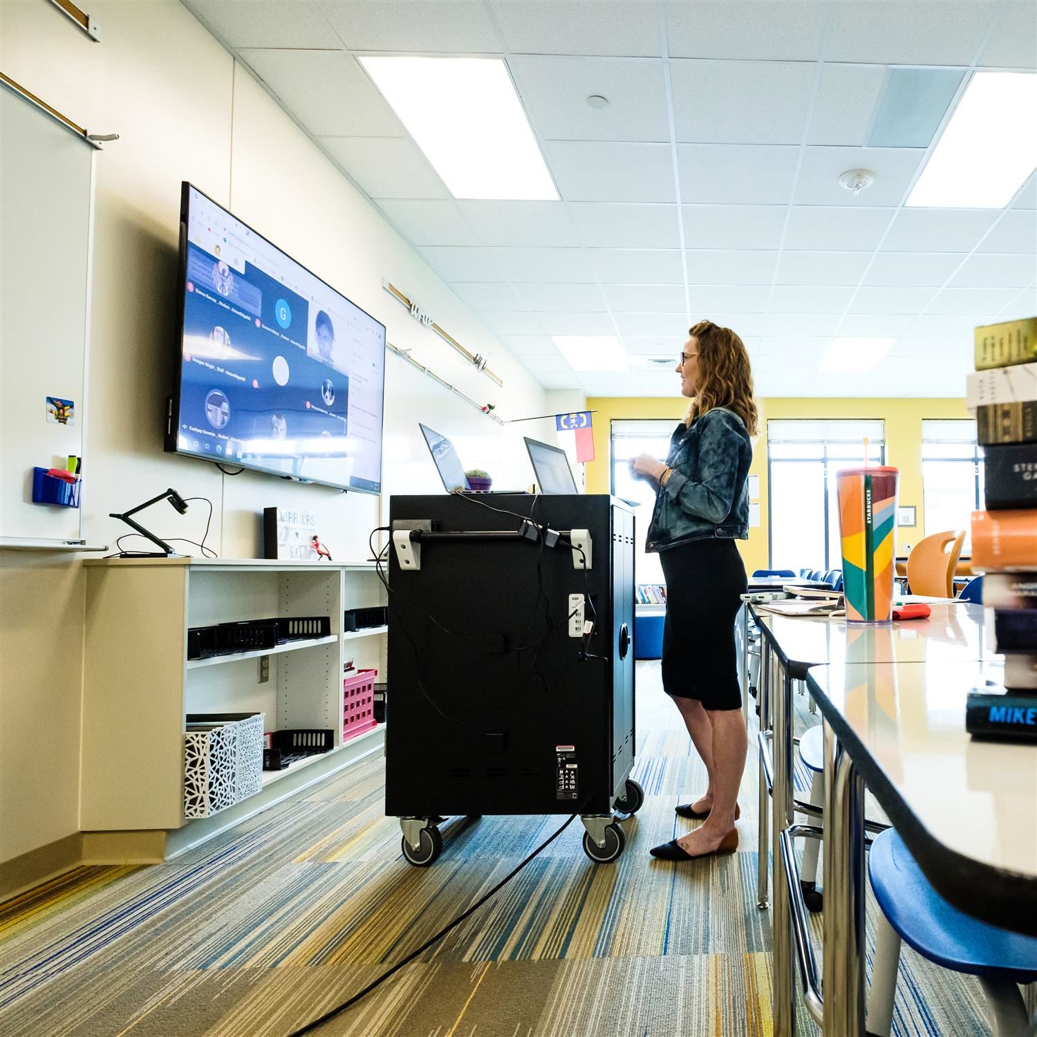  photo of woman teaching virtually in front of a TV