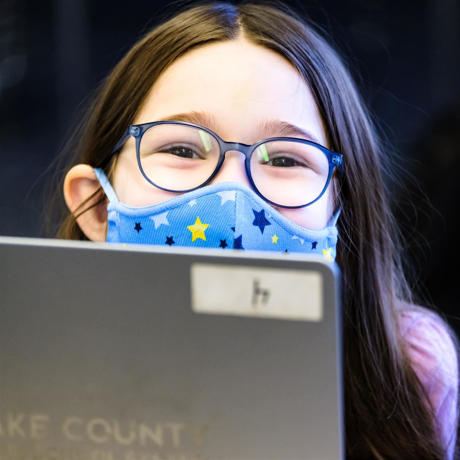  girl wearing a face mask and smiling