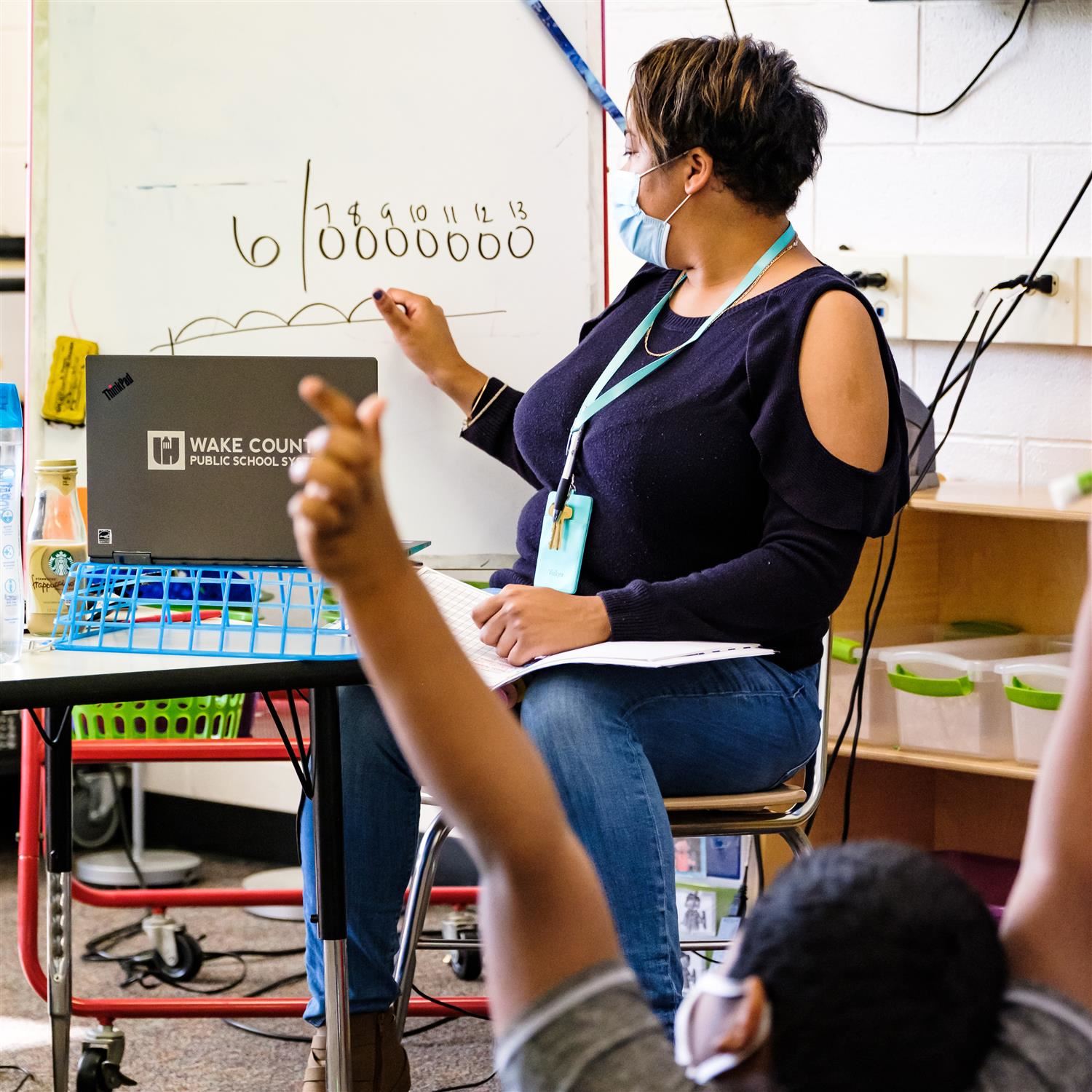  photo of a teacher writing on a board