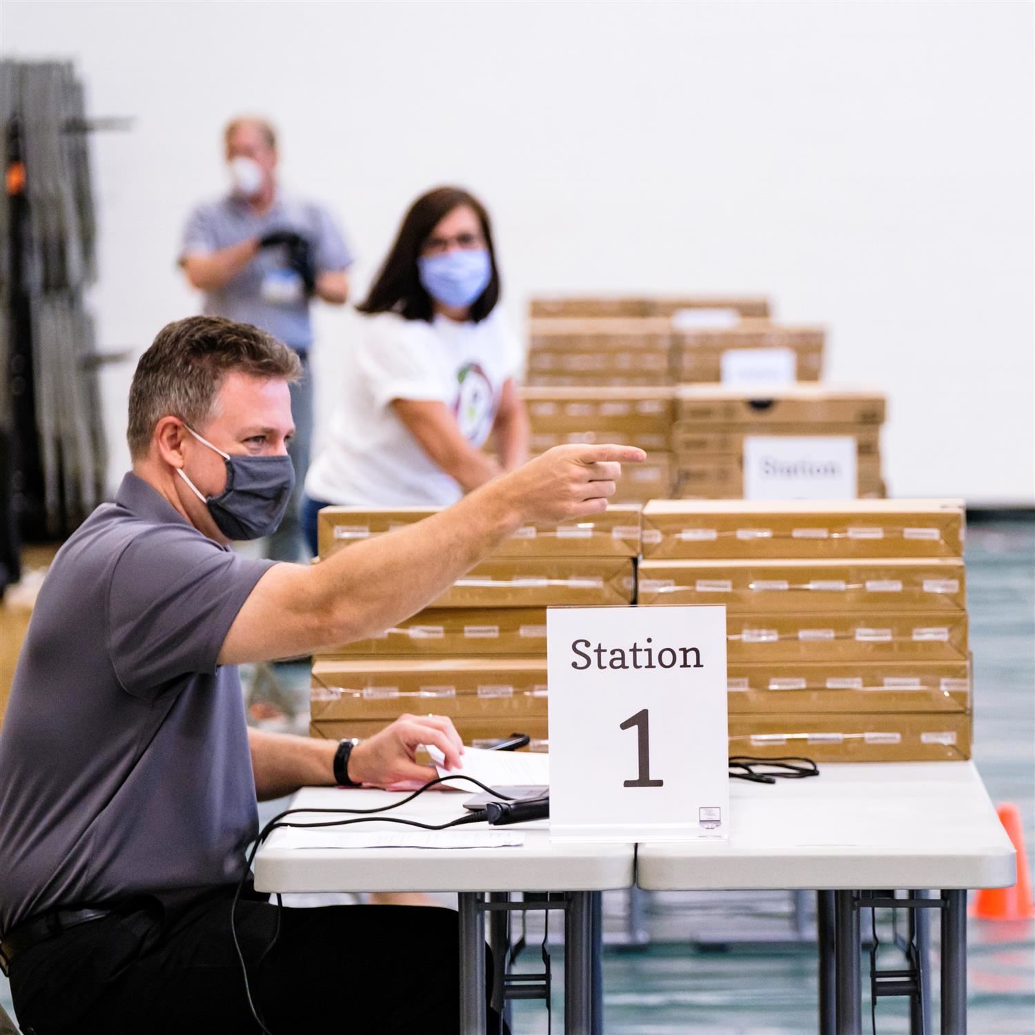  photo of man distributing laptops