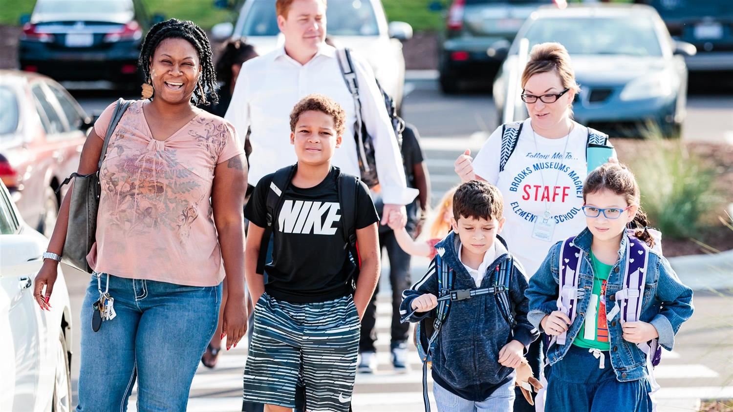 Parents walking their children into the school building 