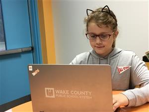 photo of young girl working on laptop 