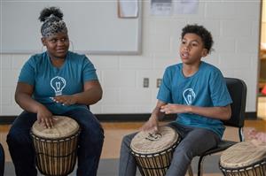 2 students playing African Drums 