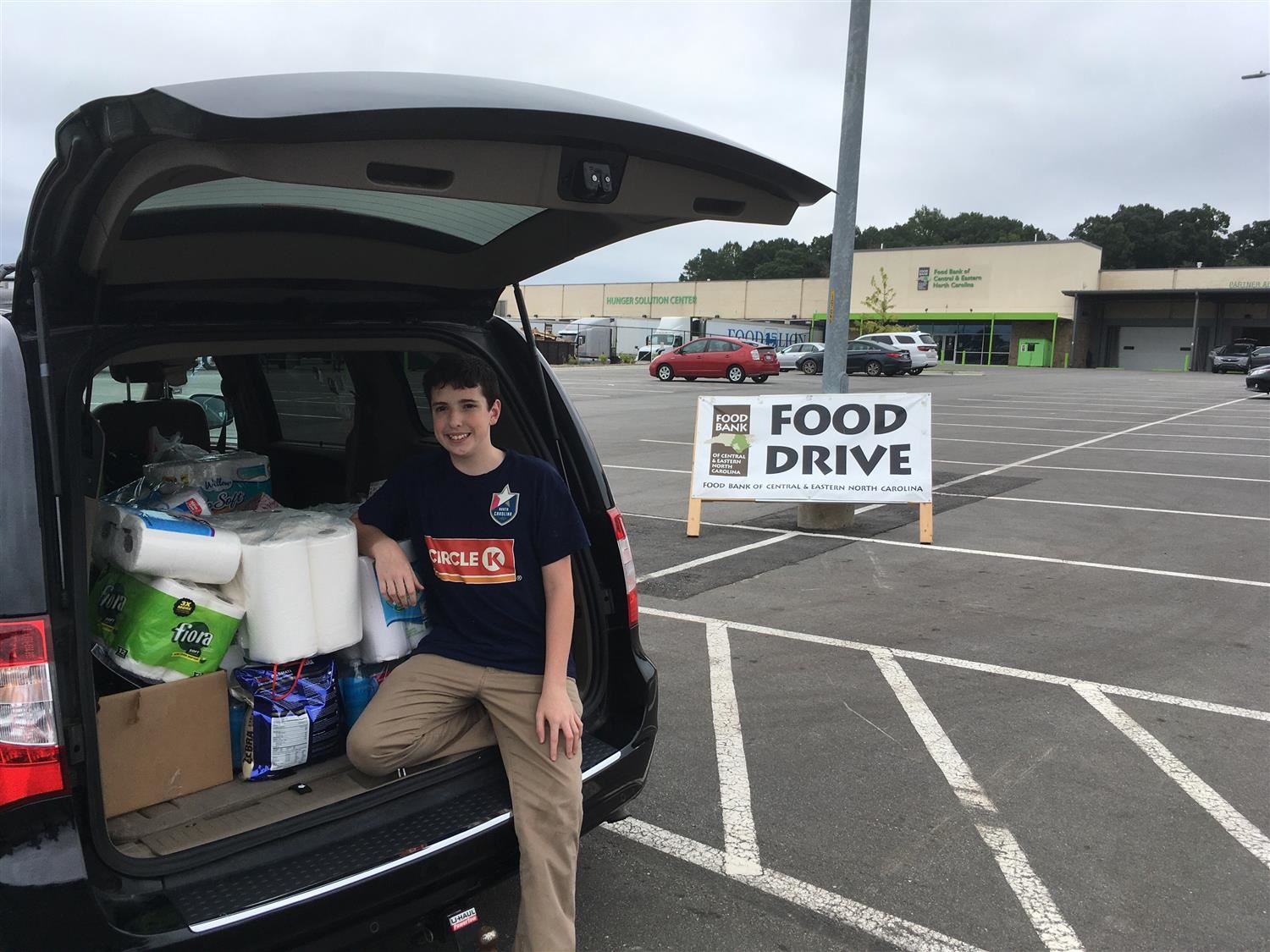 Student by car full of Food Bank goods Student by car full of Food Bank goods