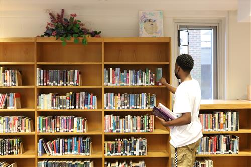 Library Assistant Jordan shelving books.