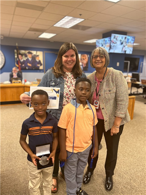 Anna Goodrum, Magnet Coordinator, and students accept the MSA Award from Superintendent Moore.