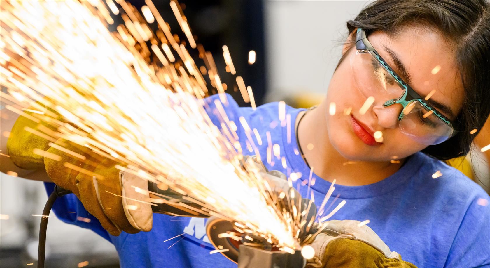 A CTE student uses an angle grinder.
