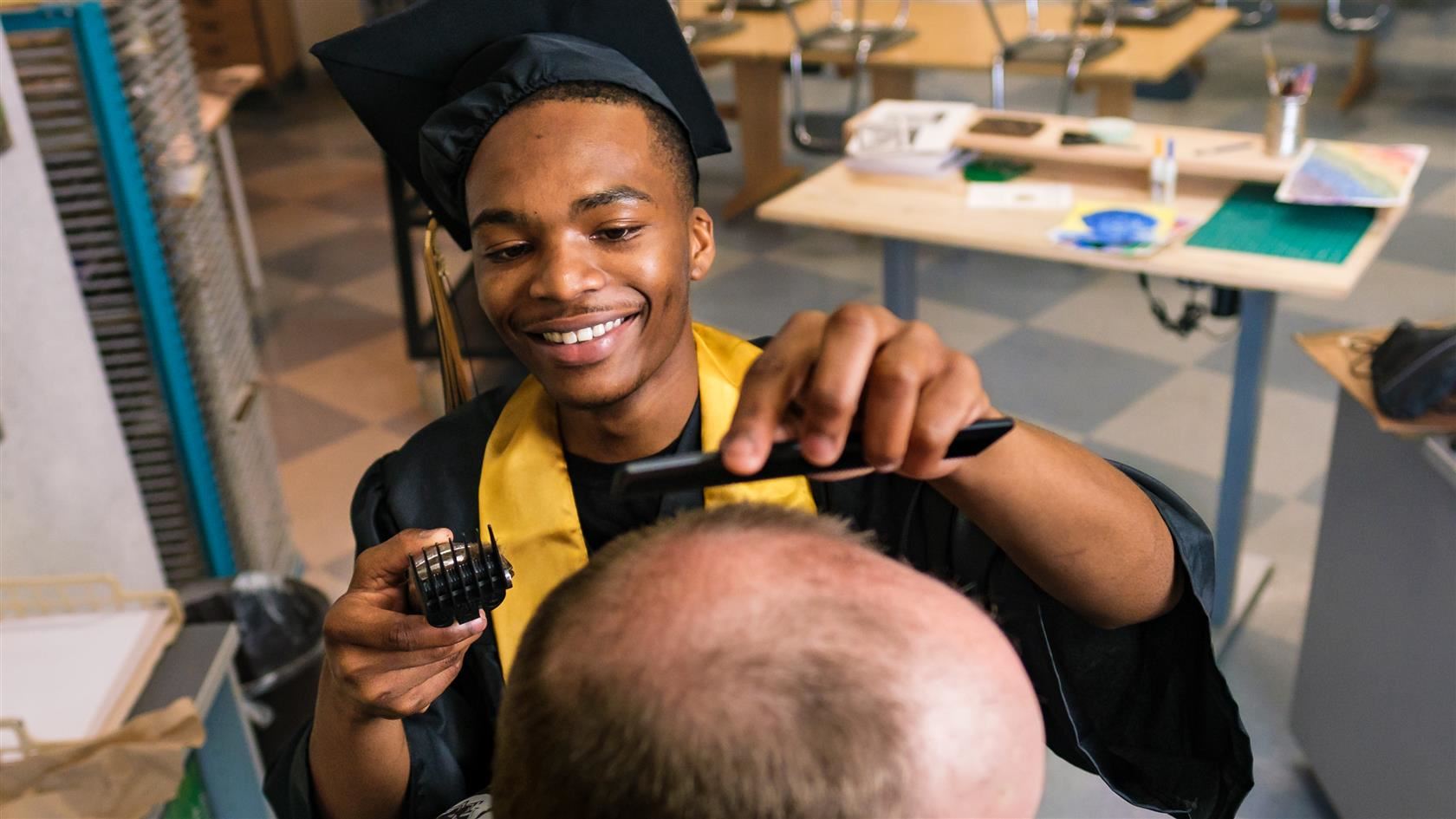 Photo of graduate Kalik Davis giving a haircut.