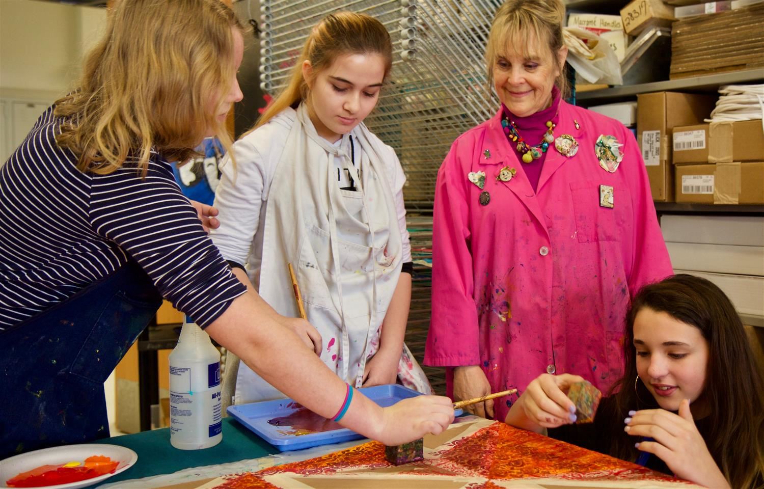 Local artist Lily Newell works with students at East Millbrook Magnet Middle School on a banner project 