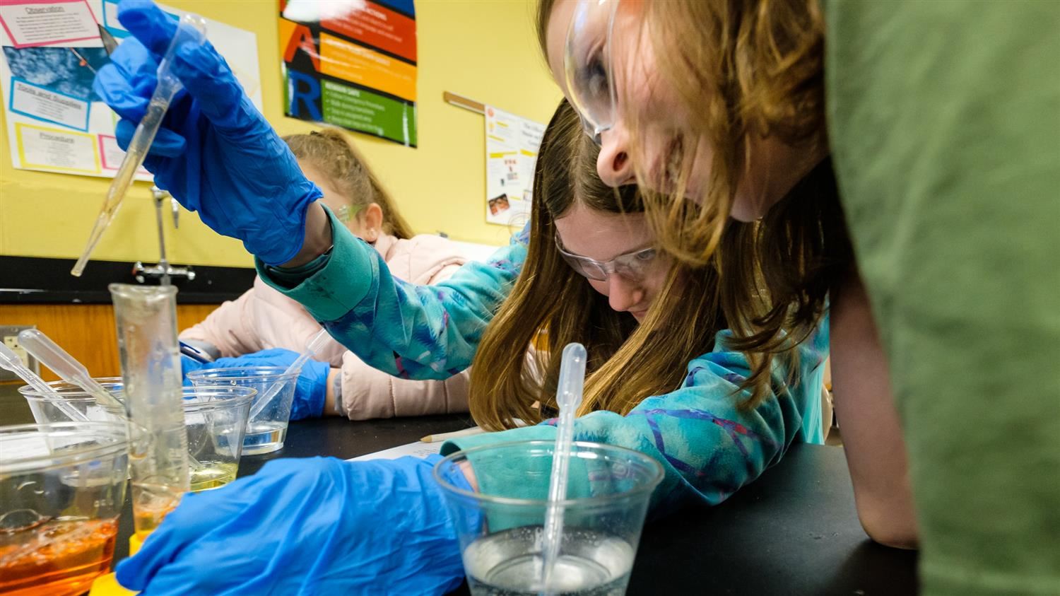 Moore Square Middle School students conduct an experiment with beakers and pipettes 