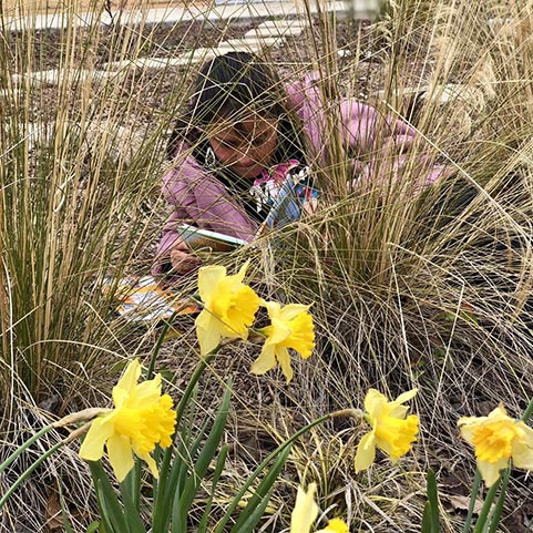  girl standing behind flowers