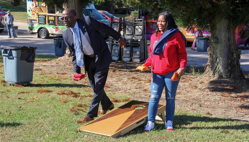 Dr. Taylor playing cornhole with staff at Wakesgiving