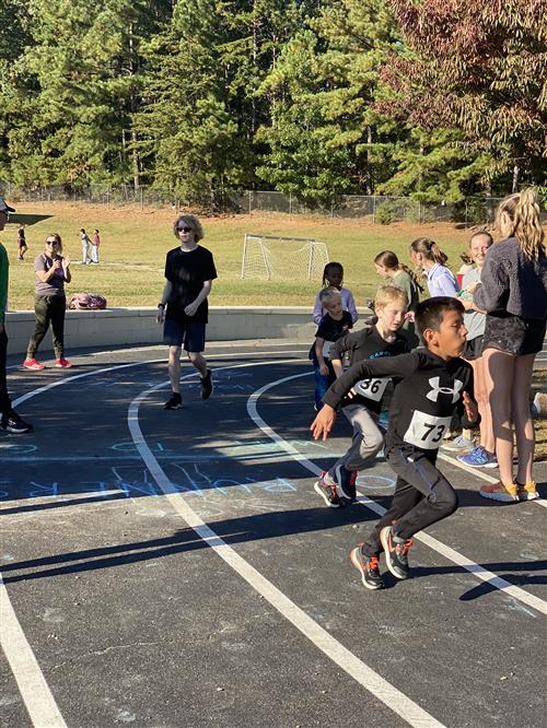 students running around the track during running club